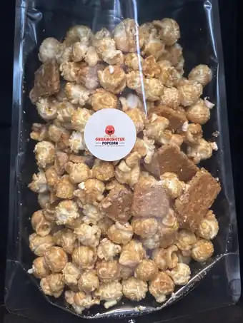 A clear Snakmonster bag of caramel-coated popcorn with large graham-style pieces